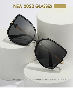 Detail of black fashion sunglasses with geometric gold metal accent on the temple arm