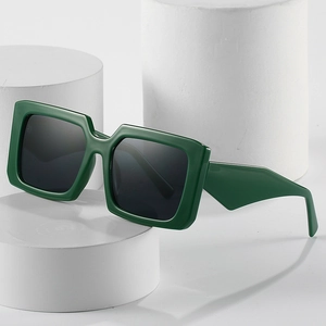 Retro chunky square sunglasses in dark green finish on a white minimalist pedestal