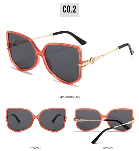 Detailed views of stylish orange oversized sunglasses with gold metal temples and gray lenses