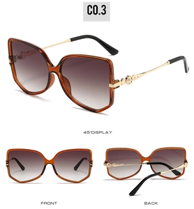 Detail view of butterfly sunglasses with amber frames and gold rose-embossed temples