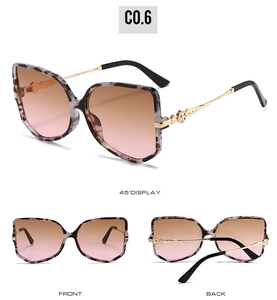 Detail of oversized leopard frame sunglasses with gold floral temples and gradient lenses