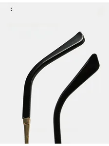Detail of ergonomic curved black temples with golden metal hinges on stylish sunglasses