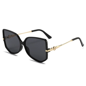 Chic black oversized butterfly sunglasses with engraved gold metal temples and grey lenses
