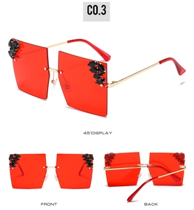 Detail of oversized rimless square sunglasses with red lenses and crystal accents