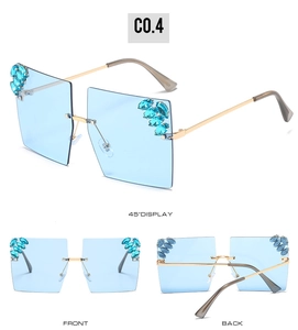 Detail view of rimless square sunglasses with blue gradient lenses and rhinestone accents
