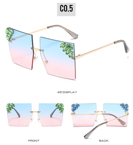 Detail of blue-pink gradient rimless sunglasses with green rhinestones on gold frame