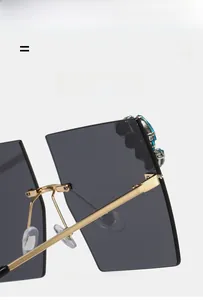 Detail of oversized rimless sunglasses with blue rhinestone accents and gold metal temples