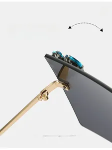 Detail of durable gold texture hinges on rimless oversized sunglasses with blue crystals