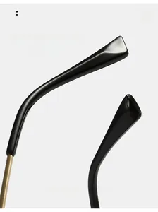 Detail of curved black glasses temples with gold metal hinge and high-gloss finish