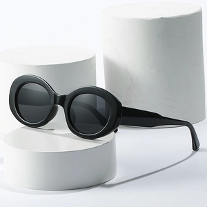 Retro black oval sunglasses for women on minimalist white display pedestals