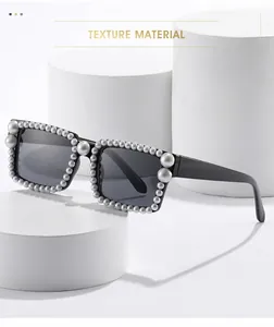 Makroaufnahme einer quadratischen schwarzen Sonnenbrille mit luxuriösen Perlenverzierungen