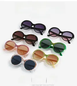 Close-up of retro round sunglasses collection featuring glitter frames and gradient lenses