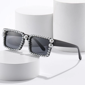 Schicke schwarze quadratische Sonnenbrille mit Perlen auf weißen Podesten