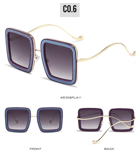 Detail view of purple glitter square sunglasses with wavy gold metal temples