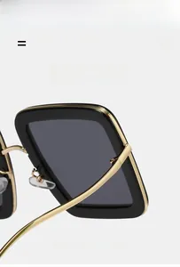 Close-up of stylish square sunglasses with black frame and golden metal temples