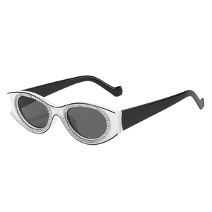 Lunettes de soleil ovales en strass avec monture blanche, branches noires et verres gris