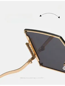 Detail of durable gold wave-shaped hinges on rimless oversized gradient sunglasses