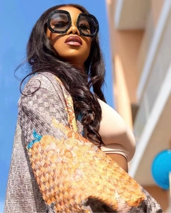 Detail of oversized oval sunglasses with black glitter frames and dark lenses for street style
