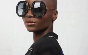 Detail view of oversized octagonal sunglasses with glitter frame and gradient lenses