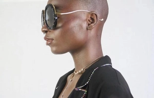 Detail of oversized black sunglasses with rhinestone frame and thin gold metal temples