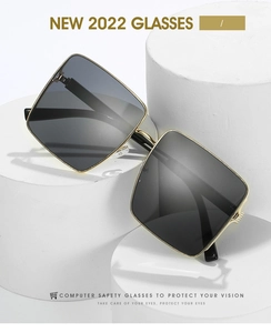 Detail of square gold metal sunglasses with dark lenses on white geometric props