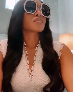 Close-up of hexagonal sunglasses with crystal-encrusted frames on a female model