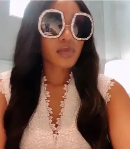 Close-up of oversized hexagonal sunglasses with crystal-encrusted frames and dark lenses