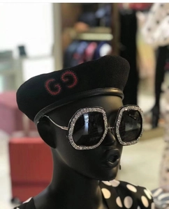 Macro shot of oversized square sunglasses with diamond-encrusted frames and deep black lenses