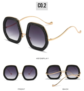 Detail of hexagon glitter sunglasses with gold metal temples and gradient purple lenses