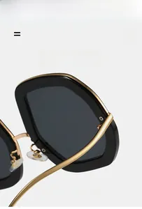 Macro detail of oval sunglasses showing sturdy black frame and gold metal hinges