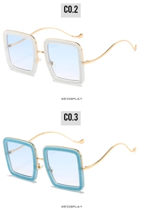 Detail view of square sunglasses with sparkling glitter frames and light blue lenses
