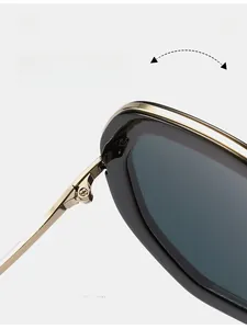 Détail de la charnière en métal doré sur lunettes de soleil carrées rétro noires avec texture