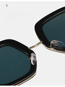 Détail des plaquettes en silicone et du pont doré sur lunettes de soleil carrées noires