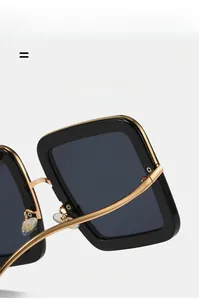 Detail view of square sunglasses featuring golden metal temples and flexible frame joints