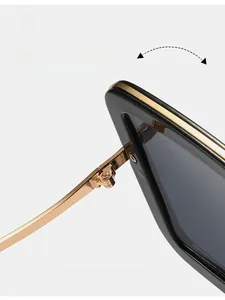 Macro detail of square sunglasses showing durable golden metal hinges and black frame