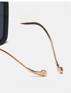 Detail of golden metal sunglasses temples with ergonomic curved design and logo