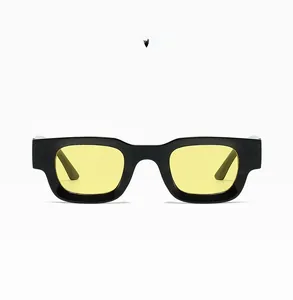 Close-up of square black frame sunglasses with yellow lenses and thick temple design