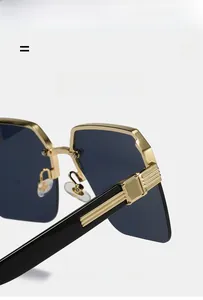 Détail des charnières dorées et des branches noires sur lunettes de soleil sans bord