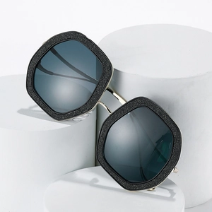 Lunettes de soleil carrées oversize avec monture noire pailletée et verres gris foncé