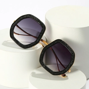 Glitter black hexagonal oversized sunglasses with gradient purple lenses on display
