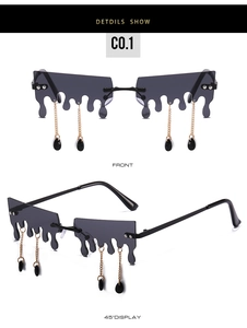 Détail de lunettes à lentilles fluides avec chaînes dorées et pampilles gouttes noires