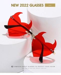 Detailed close-up of red heart-shaped devil sunglasses with gold metal bridge and sleek frame