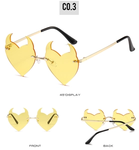 Detailed views of yellow devil horn sunglasses with gold metal frames and 45 degree angle