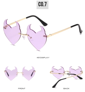 Detail view of devil heart rimless sunglasses with purple lenses and gold metal frames