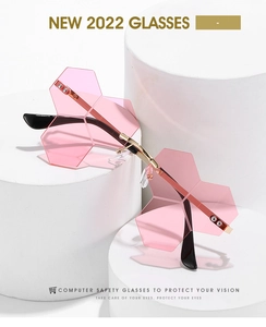 Detail view of pink rimless geometric sunglasses with gold metal frame and layered lenses
