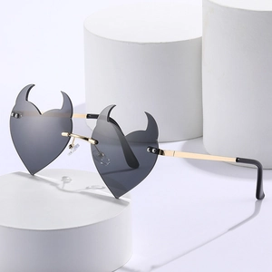 Frameless heart sunglasses with devil horns and gold metal frame on white decor