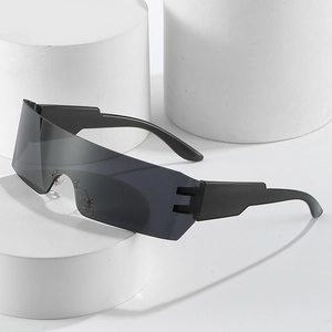Futuristic black wrap-around shield sunglasses on white podium display stand