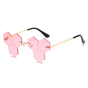 Pink hexagonal frameless hip hop sunglasses with gold metal temples on white background