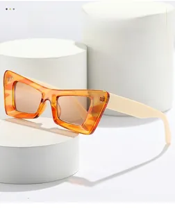 Détail de lunettes de soleil œil-de-chat vintage avec monture orange et branches blanches
