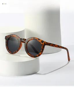 Detail shot of vintage tortoise shell round sunglasses on a white geometric platform